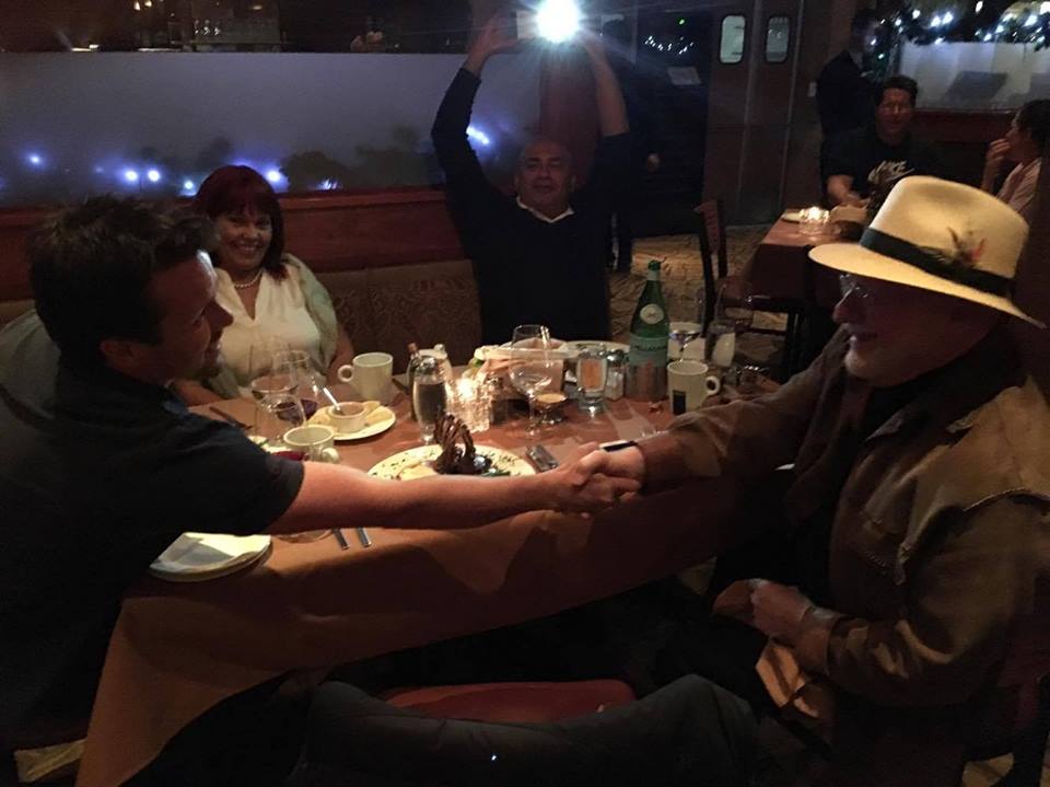 David Jenyns shaking hands with Michael E. Gerber over dinner in Carlsbad